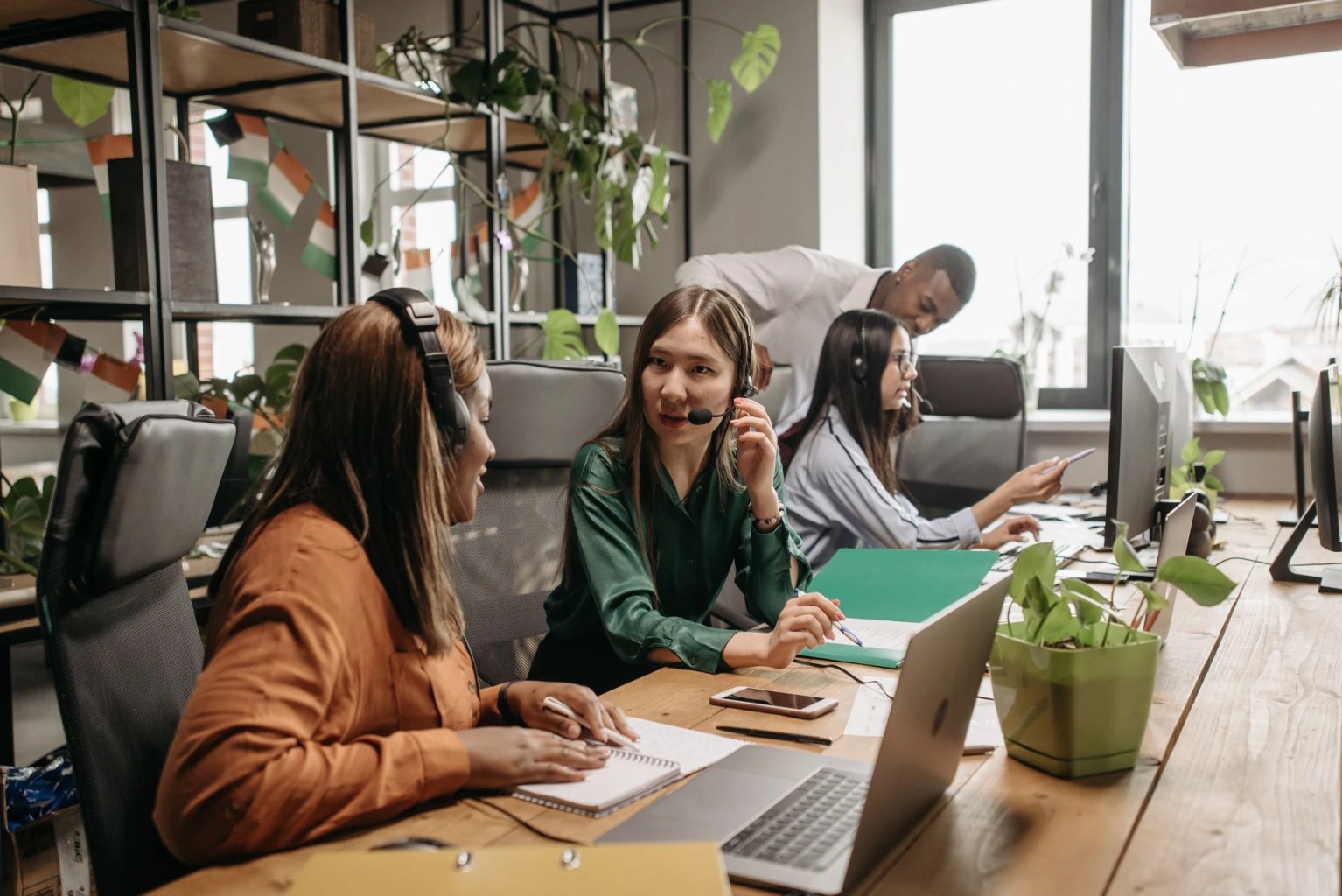 Equipo de atención al cliente colaborando en una oficina como representación de la creación de un manual de servicio al cliente