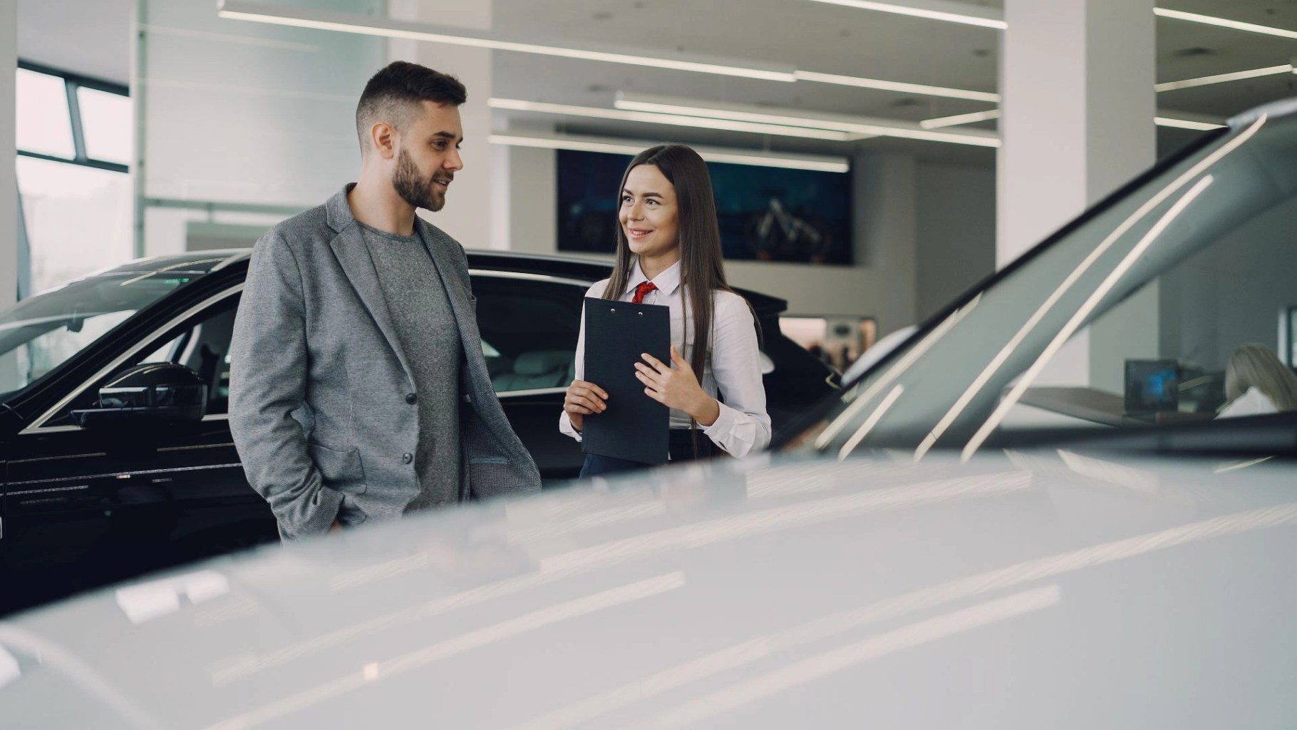 Asesora comercial atendiendo a un cliente en una sala de ventas, imagen para ilustrar la capacidad de un equipo de ventas.