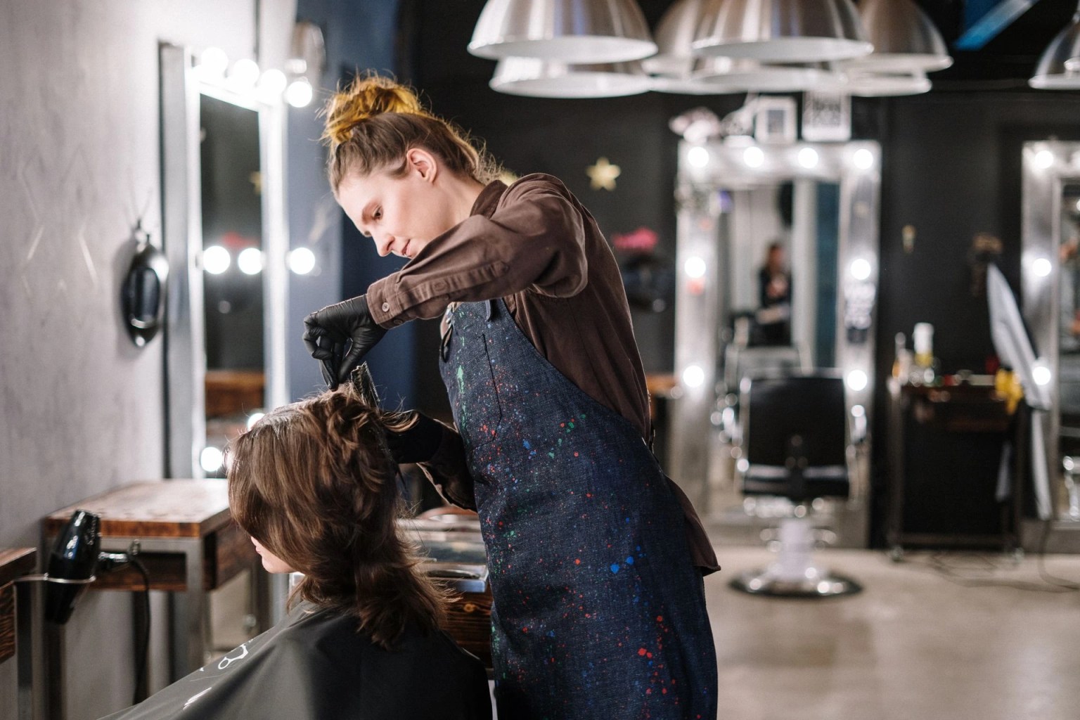 Estilista atendiendo a una clienta en salón de belleza, imagen principal sobre cómo crear una peluquería o barbería desde cero