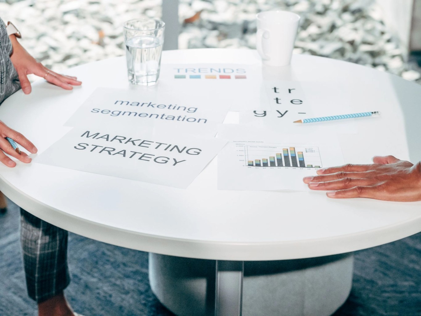 Personas revisando documentos y graficos de marketing sobre una mesa, imagen para ilustrar como medir el impacto real de una campaña.