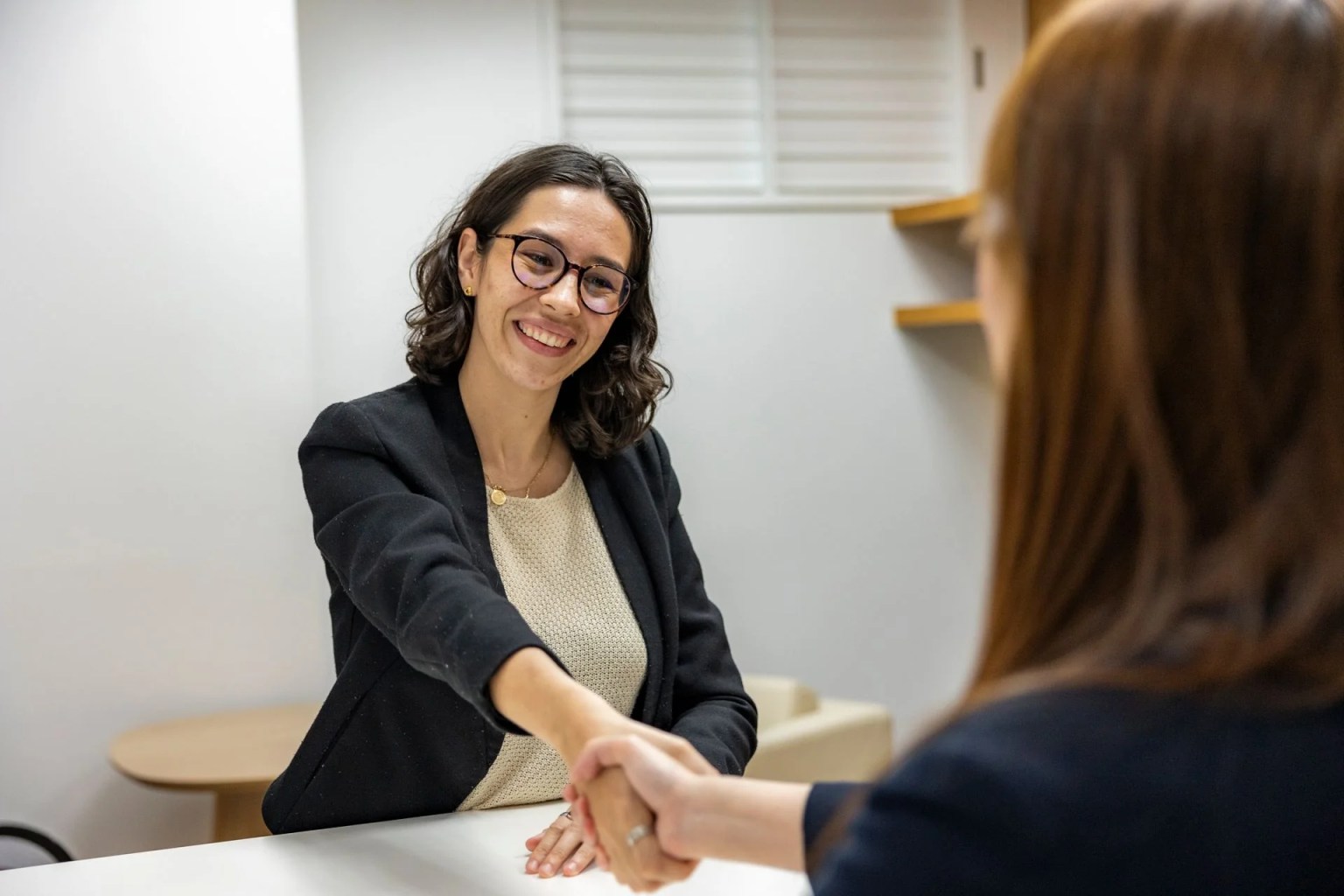 Entrevista laboral y saludo entre dos personas para ilustrar la calidad de la contratación.