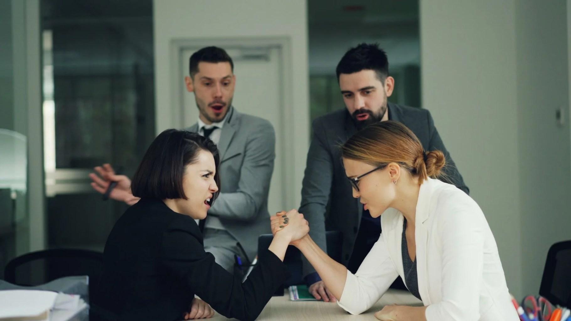Dos profesionales compitiendo mientras un equipo observa para ilustrar el modelo de Stackelberg, la relación entre empresa líder y seguidora y la competencia por cantidades.