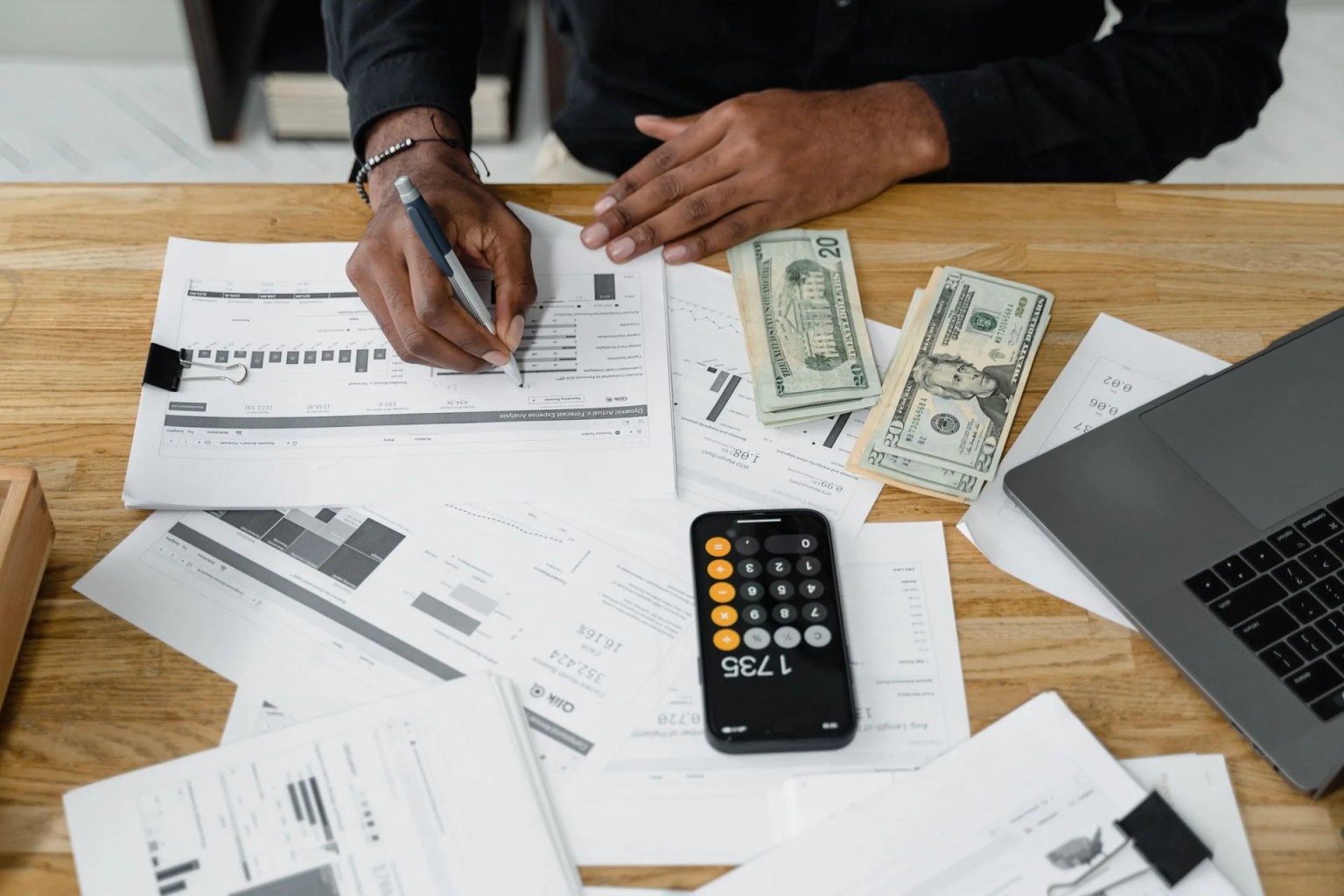 Análisis financiero con documentos, efectivo y calculadora para explicar la tasa interna de retorno modificada (MIRR).